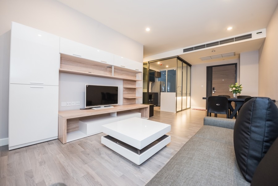 Elegant, custom-made bookcase TV unit with large, white wooden shelves, designed for a modern, airy space.  