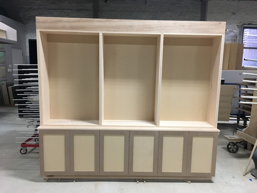 Custom, built-in bookcase unit with spacious wooden shelves in a light color, blending seamlessly with modern interiors.  