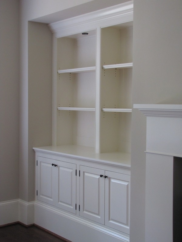 Custom-built wooden bookcase unit in a natural wood color, offering spacious and large shelves for extensive collections.  