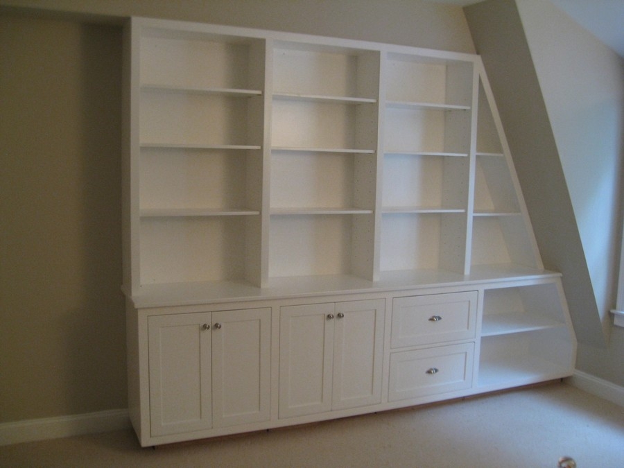 Elegant, hazelnut-colored custom bookcase unit, designed with large wooden shelves for a modern and cozy reading area.  