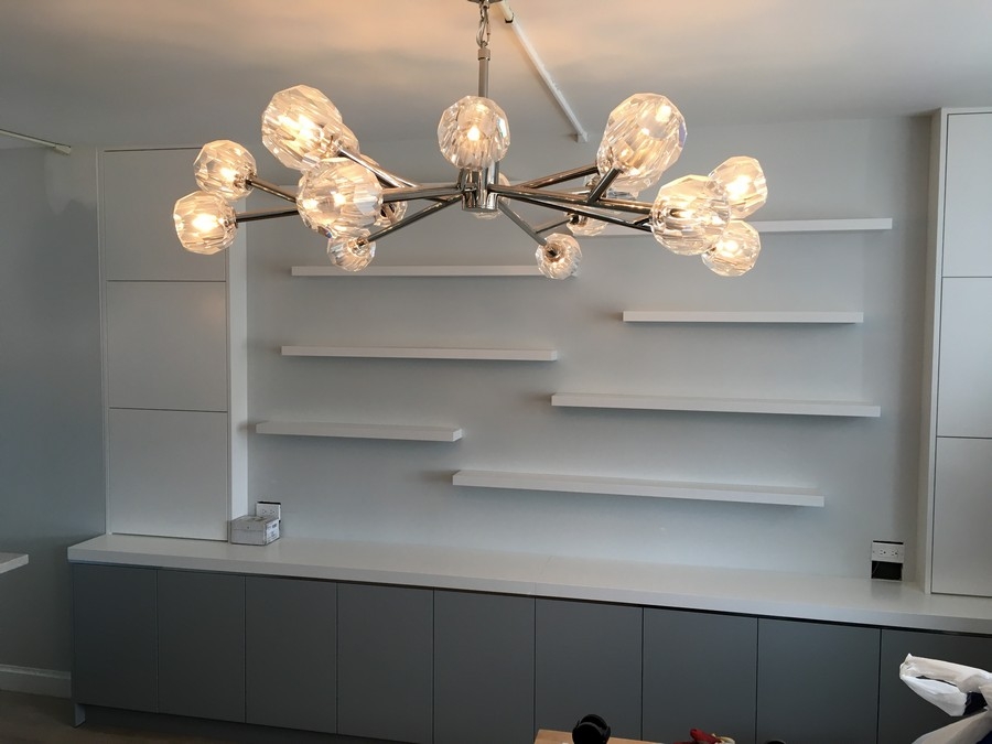 Sleek, full-wall custom bookcase with spacious shelves in a clean white color, perfect for modern interiors.  