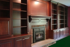 Spacious, full-wall custom bookcase unit in a sleek, modern design with natural wood color shelves.  