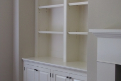 Custom-built wooden bookcase unit in a natural wood color, offering spacious and large shelves for extensive collections.  
