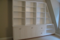 Elegant, hazelnut-colored custom bookcase unit, designed with large wooden shelves for a modern and cozy reading area.  