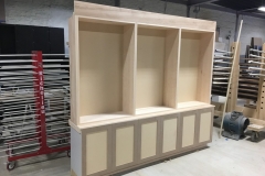 Spacious, custom bookcase unit in a light natural wood color, featuring big, built-in shelves for a modern home library.  