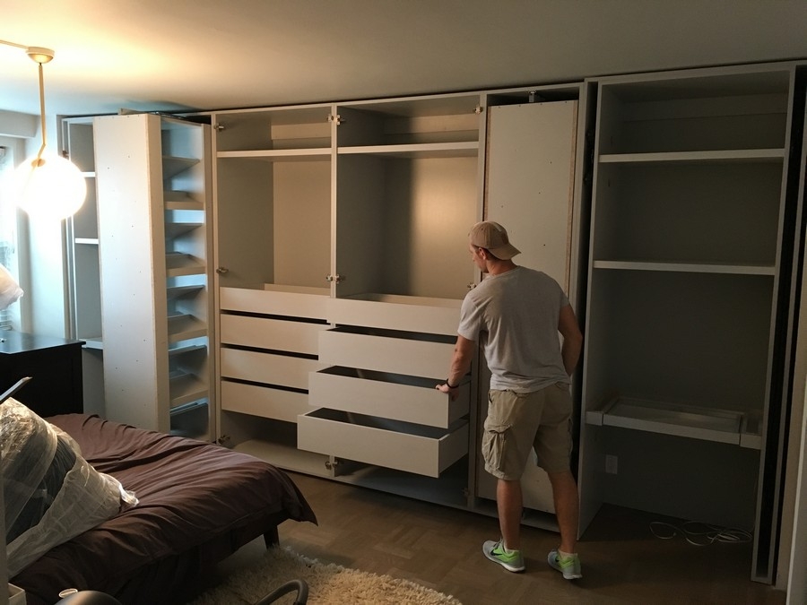 Elegant, custom-built wardrobe with spacious, white cabinets and a contemporary design.             