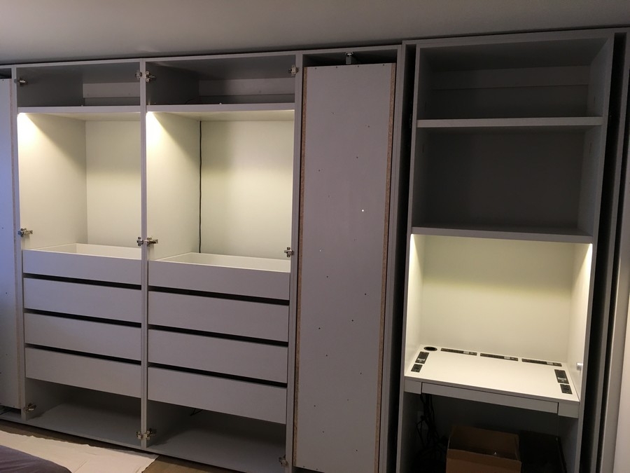 Spacious, modern wardrobe custom-designed with light-colored wood cabinets.            