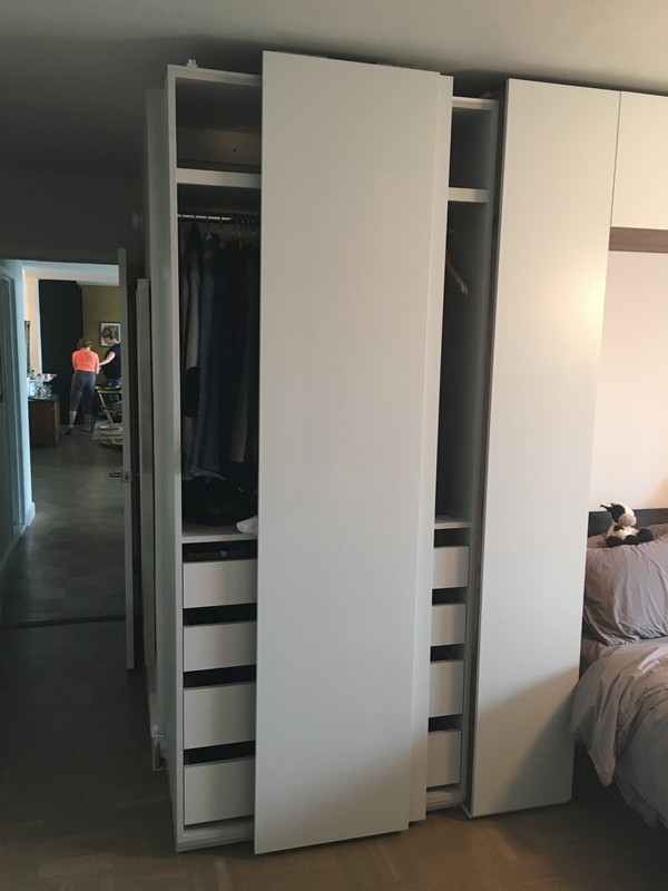 Big, custom wardrobe with built-in, natural wood cabinets and a sleek, contemporary look.             