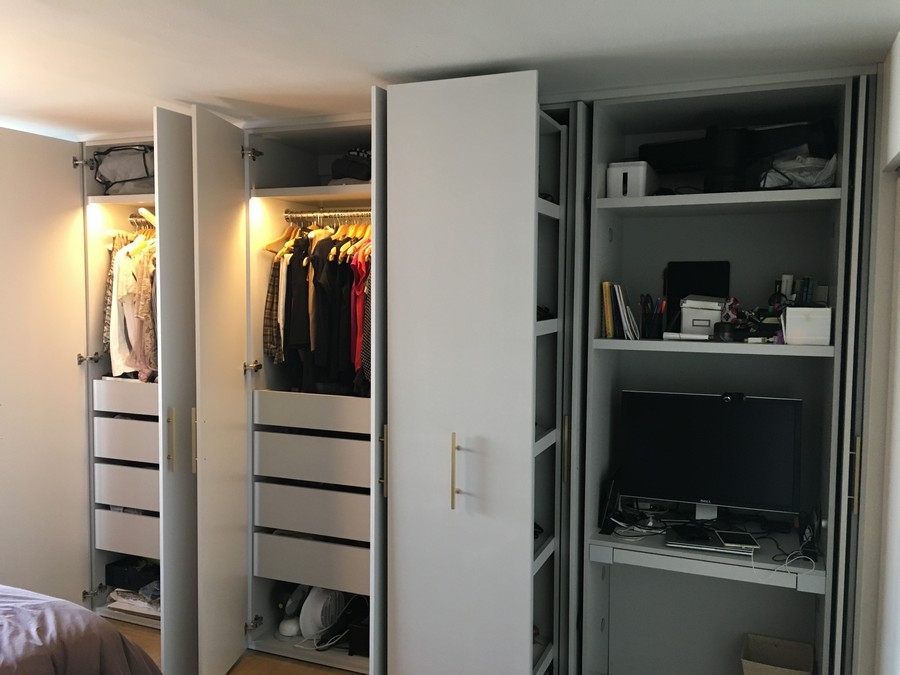 Modern, custom-built wardrobe with full wall, white cabinets and a contemporary finish.            