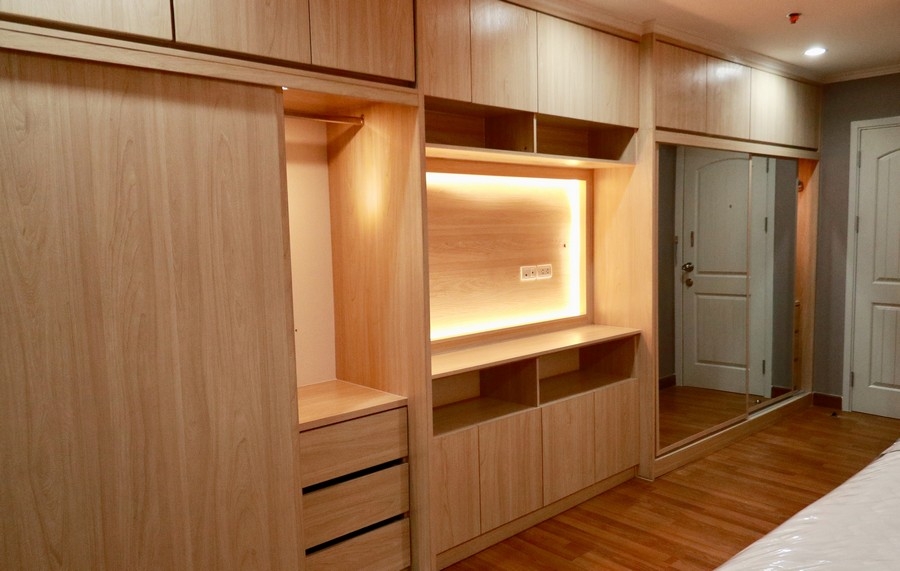 Spacious, custom wardrobe with full wall, white cabinets in a contemporary style.            