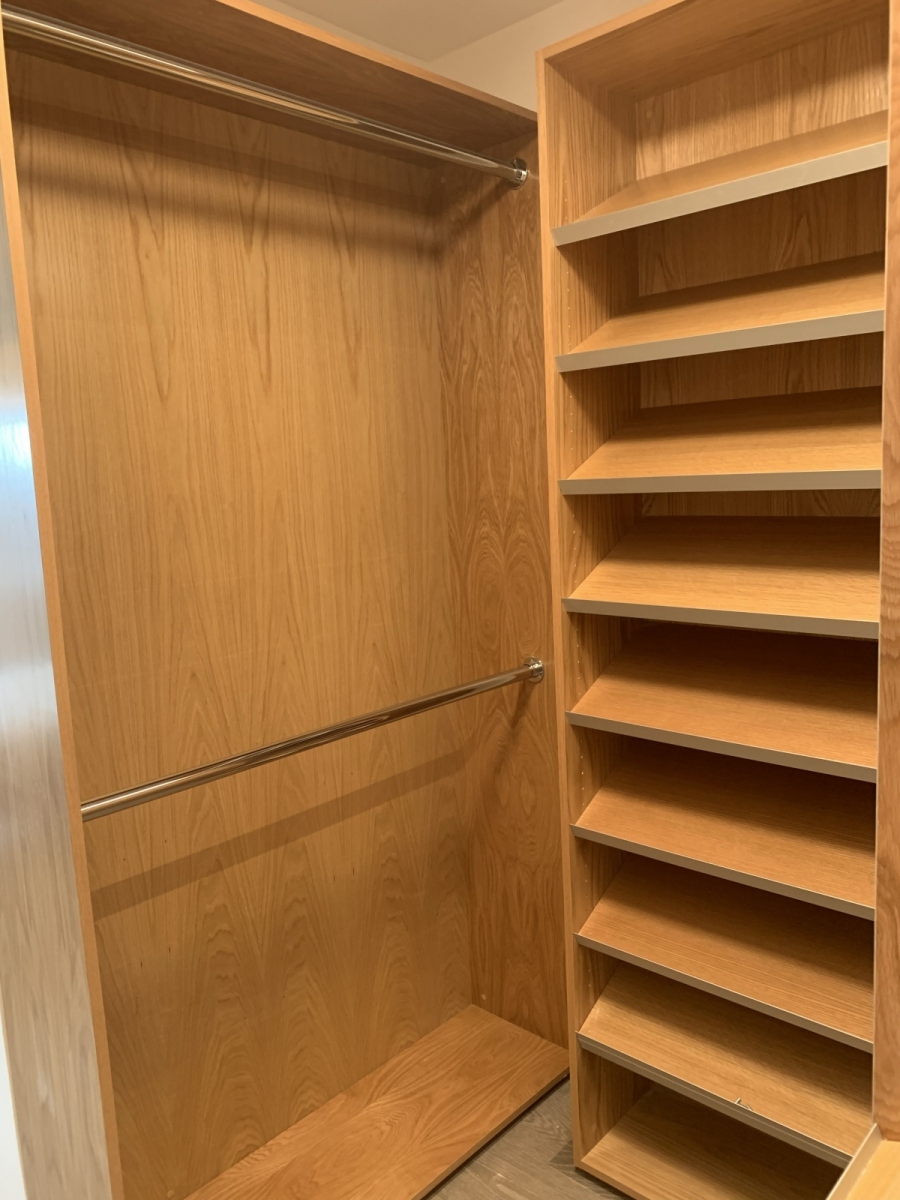 Custom, built-in wardrobe with large, hazelnut-colored cabinets and a modern design.            