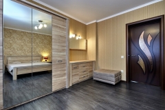 Custom-made modern wardrobe with spacious wooden cabinets in a light natural color.             