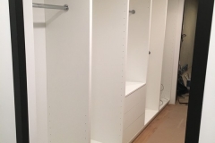 Elegant, custom-made wardrobe with big, white cabinets and a contemporary feel.            