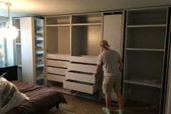 Elegant, custom-built wardrobe with spacious, white cabinets and a contemporary design.             