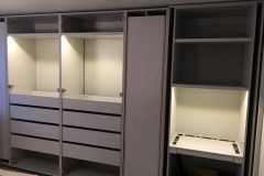 Spacious, modern wardrobe custom-designed with light-colored wood cabinets.            