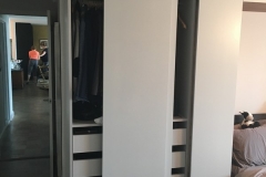 Big, custom wardrobe with built-in, natural wood cabinets and a sleek, contemporary look.             