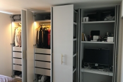 Modern, custom-built wardrobe with full wall, white cabinets and a contemporary finish.            