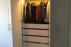 Sleek, custom-designed wardrobe with large, wood cabinets in a natural tone.             