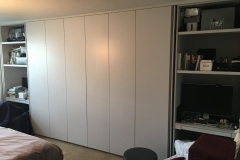 Custom, spacious wardrobe with built-in cabinets in a modern, light wood color.            