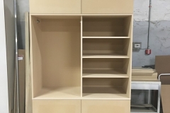 Custom, big wardrobe with built-in cabinets in a natural, light wood color.             