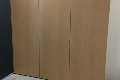 Custom, spacious wardrobe with built-in, light-colored cabinets and a contemporary look.             