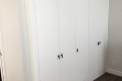 Sleek, custom wardrobe with spacious, hazelnut-colored cabinets and a modern design.            