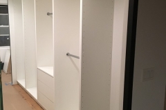 Custom-built, full wall wardrobe with large cabinets in a modern, light color.            