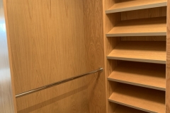 Custom, built-in wardrobe with large, hazelnut-colored cabinets and a modern design.            