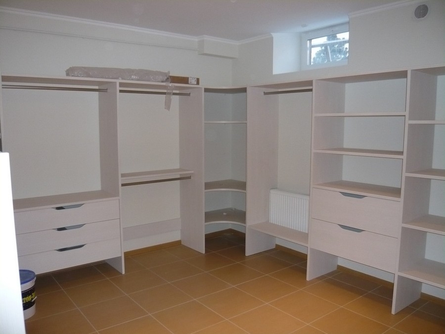 Custom, full-room closet with built-in wooden storage in a darker color, designed for a sophisticated, modern look.  