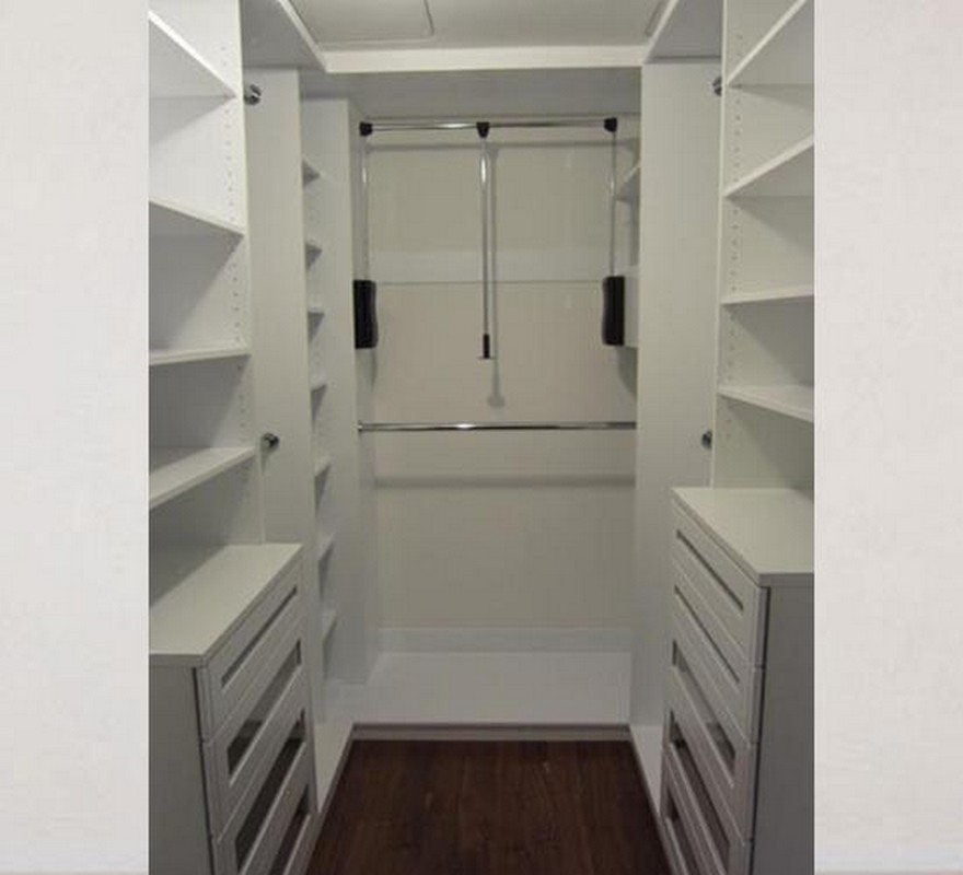 Spacious walk-in closet, custom-built with large wooden units in a natural wood color, offering a blend of style and storage.  