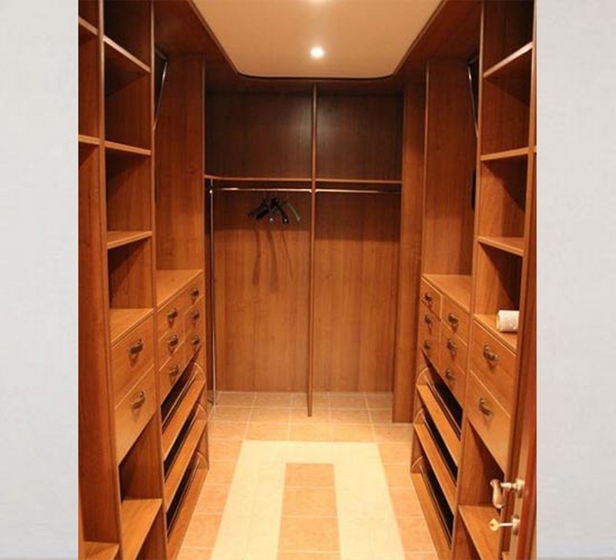 Custom-designed closet featuring full-wall wooden shelving in a light, airy color, for a modern, spacious storage solution.  