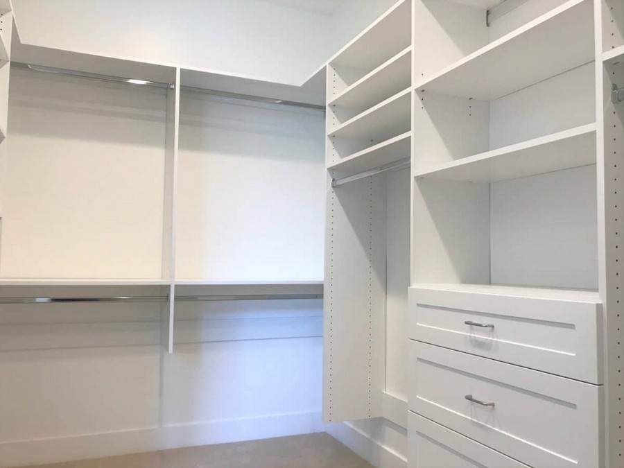 Big, custom-made walk-in closet with built-in wooden storage in a rich, darker color, providing elegant organization options.  
