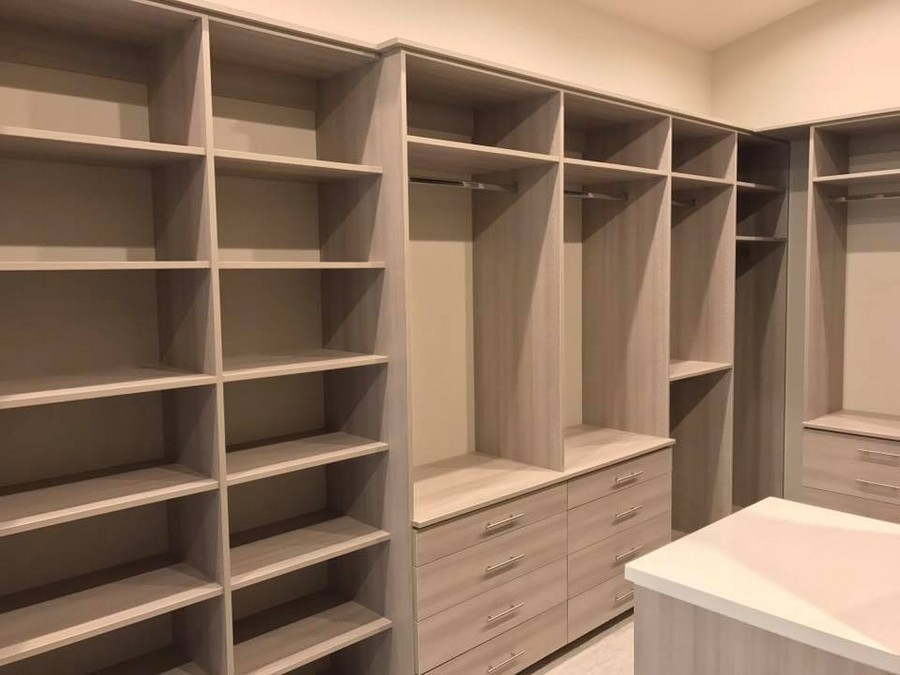 Modern, custom closet featuring large, white wooden shelves and drawers, designed for sophisticated organization.  