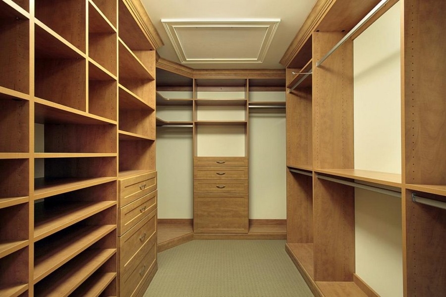 Custom-designed full room closet with spacious shelving and hanging areas in a light wood color, maximizing storage.  
