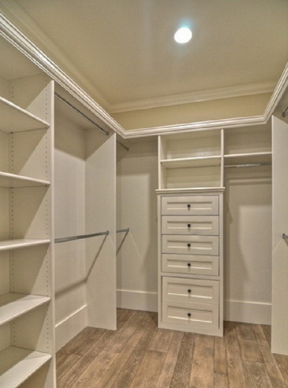Modern, custom closet design with big, hazelnut-colored wooden shelves, creating a warm and inviting walk-in space.  