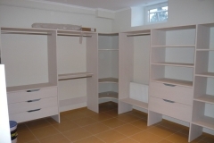 Custom, full-room closet with built-in wooden storage in a darker color, designed for a sophisticated, modern look.  