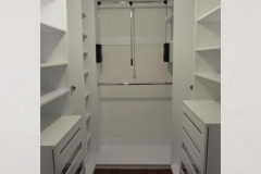 Spacious walk-in closet, custom-built with large wooden units in a natural wood color, offering a blend of style and storage.  