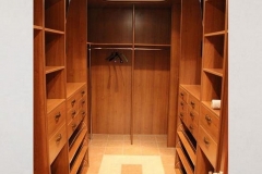 Custom-designed closet featuring full-wall wooden shelving in a light, airy color, for a modern, spacious storage solution.  