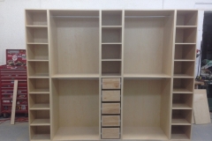 Elegant, full-room custom closet with built-in shelving in a warm hazelnut wood, designed for extensive storage and luxury.  