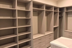 Modern, custom closet featuring large, white wooden shelves and drawers, designed for sophisticated organization.  