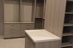 Large, custom walk-in closet featuring full-wall, built-in wooden units in a crisp white color for a modern interior.  