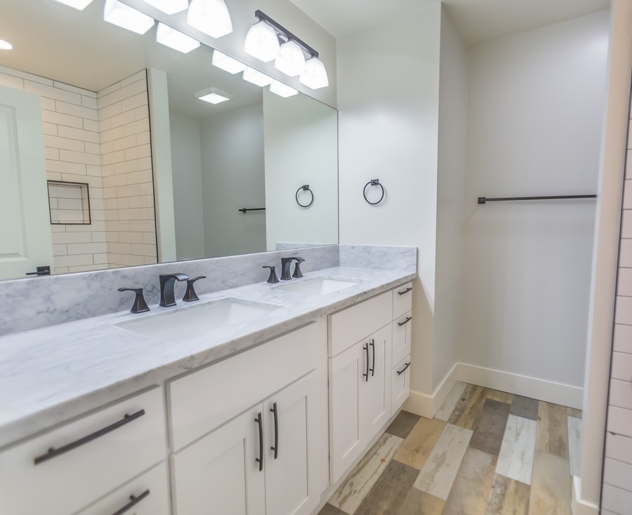 a full-white custom vanity and a big mirror
