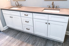 a custom 2-sink vanity with white cabinets and brown top