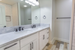 a full-white custom vanity and a big mirror