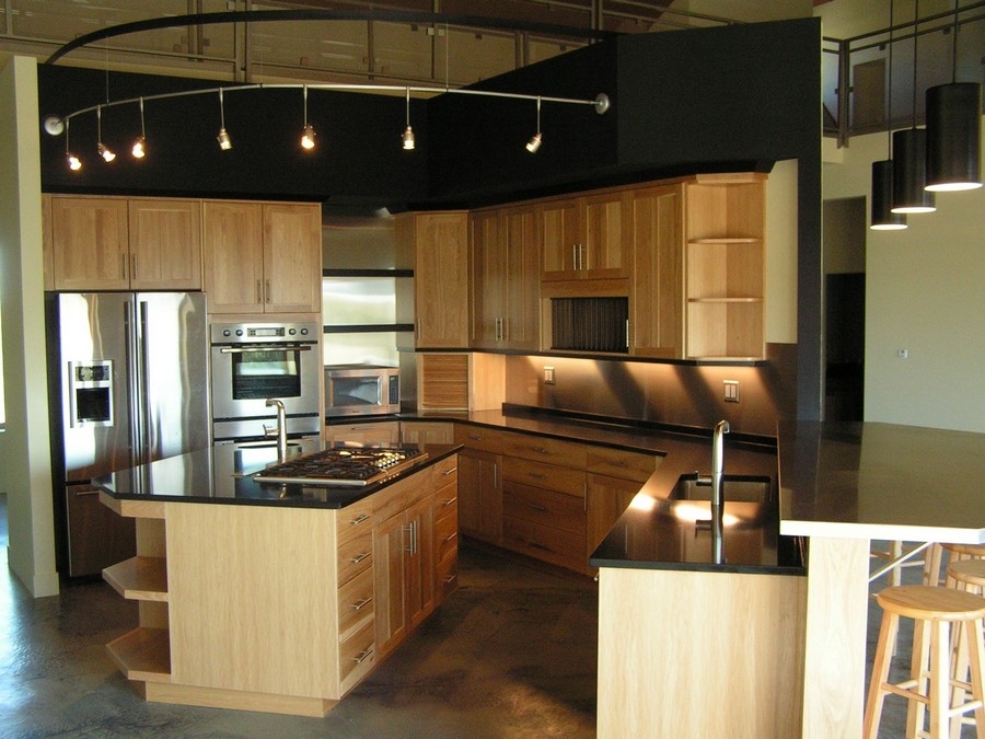 Custom-built modern kitchen with spacious cabinets in a light wood color and a big island.