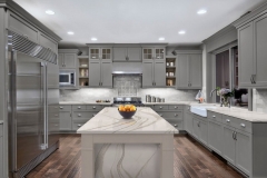 Modern kitchen with big, light-colored cabinets, custom design, and a cozy island.