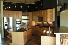 Custom-built modern kitchen with spacious cabinets in a light wood color and a big island.