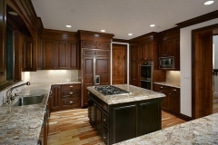 Spacious, custom-designed kitchen with big, natural wood cabinets and a modern island.