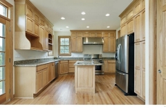 Custom, airy kitchen with spacious cabinets in a light, natural wood and a modern aesthetic.