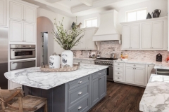 Sleek, spacious kitchen with custom white cabinets, a big island, and modern furnishings.